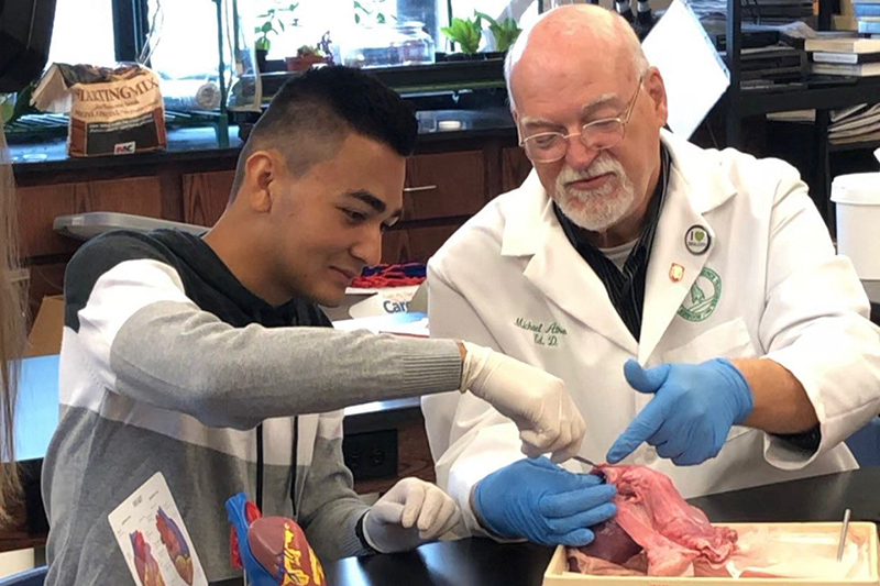student and professor disecting