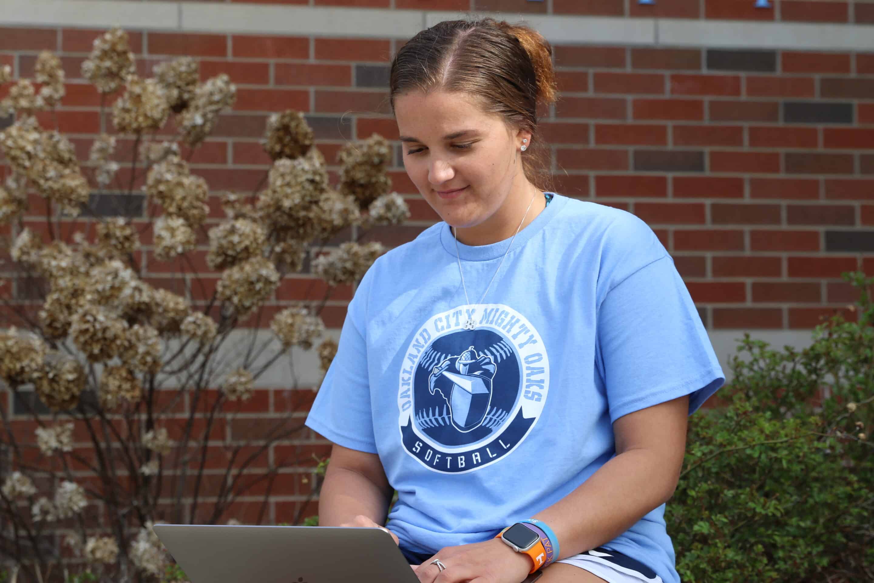 student sitting outside using computer
